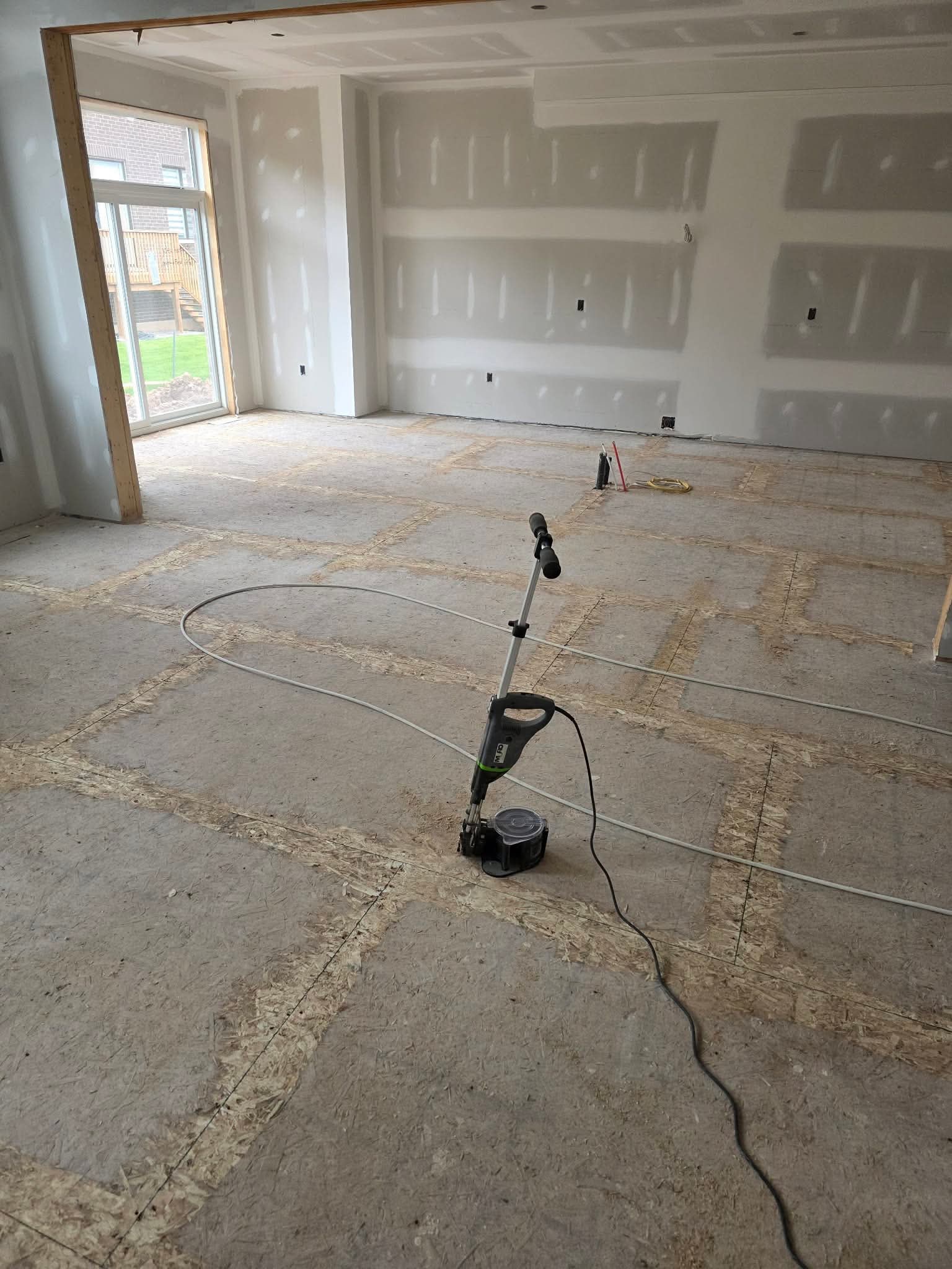 Prepared subfloor with sanding seams visible across a large room