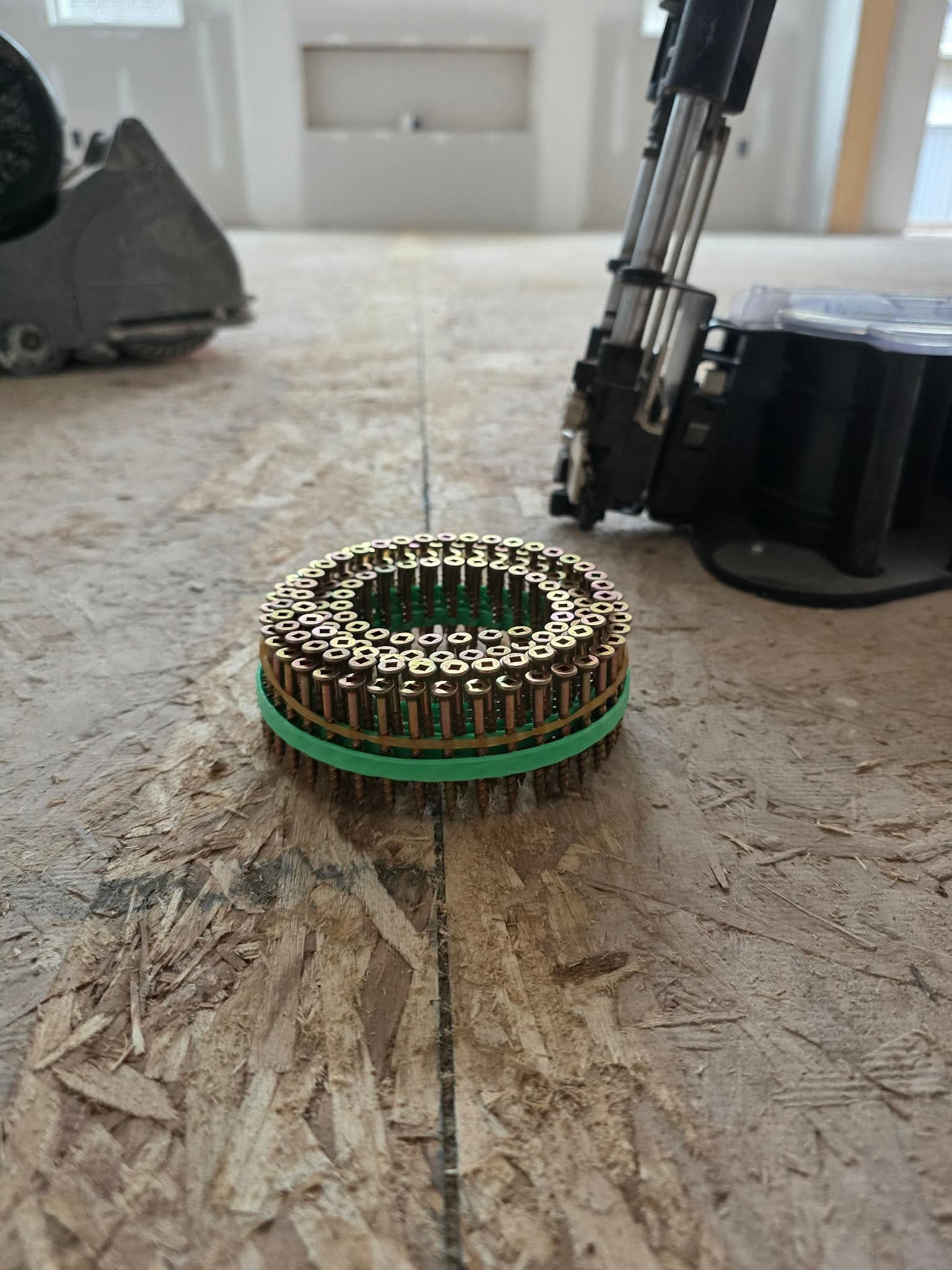 Close-up of Muro screw coil and specialty screw gun on subfloor